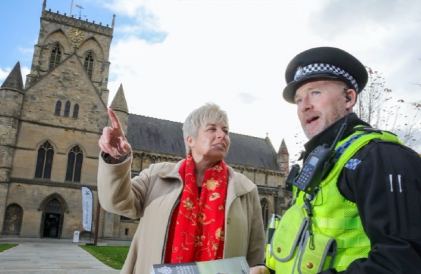 Lia Nici MP (Left) talking to C.I. Dave Stephenson (Right), standing in front of a church.